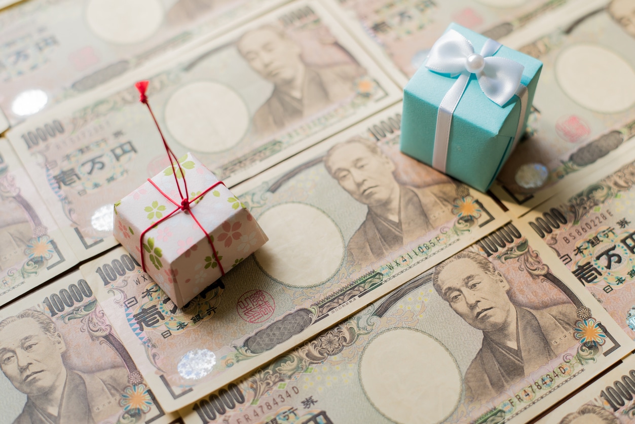 Japanese yen banknotes with decorative gift boxes, symbolizing financial transfers and gift tax obligations in Japan.